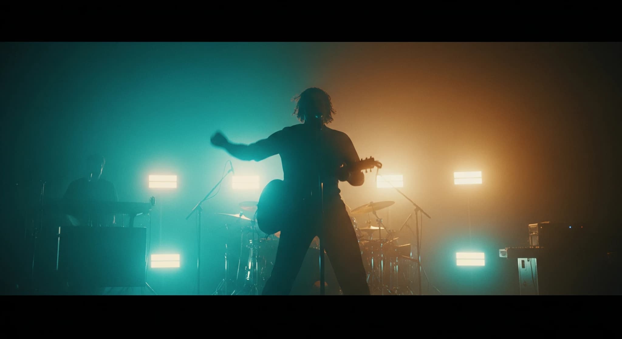 Clip musical IA, image de clip vibrante à l'éclairage coloré dramatique, un artiste en performance, atmosphère énergique, mouvement